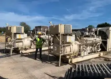 amir standing in front of a two generators