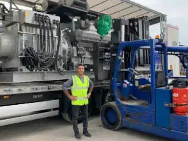 amir in front of a generator being loaded onto the lorry