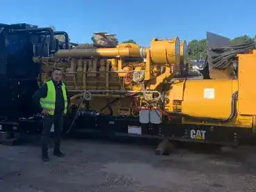 amir standing in front of a newly bought yellow generator